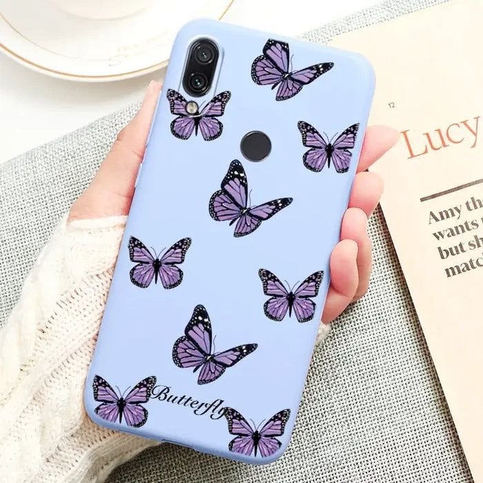 a woman holding a phone case with butterflies on it