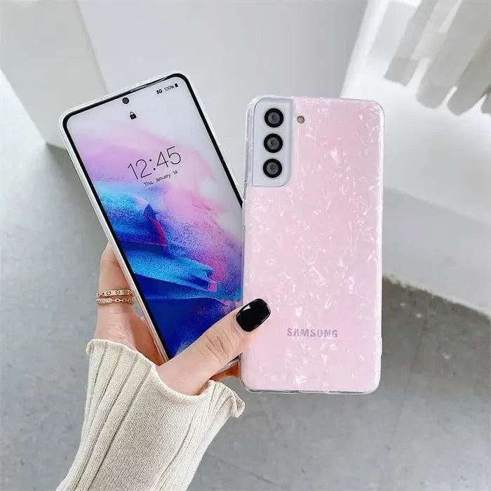 a woman holding a pink and blue phone case