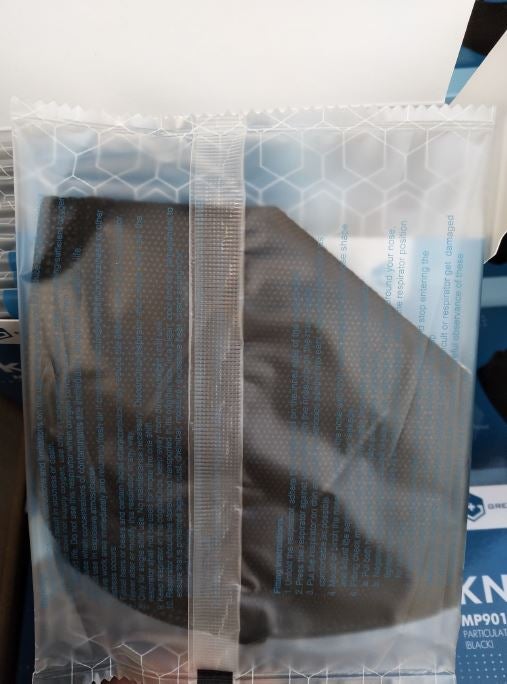 Black KN95 face mask in clear plastic wrapper