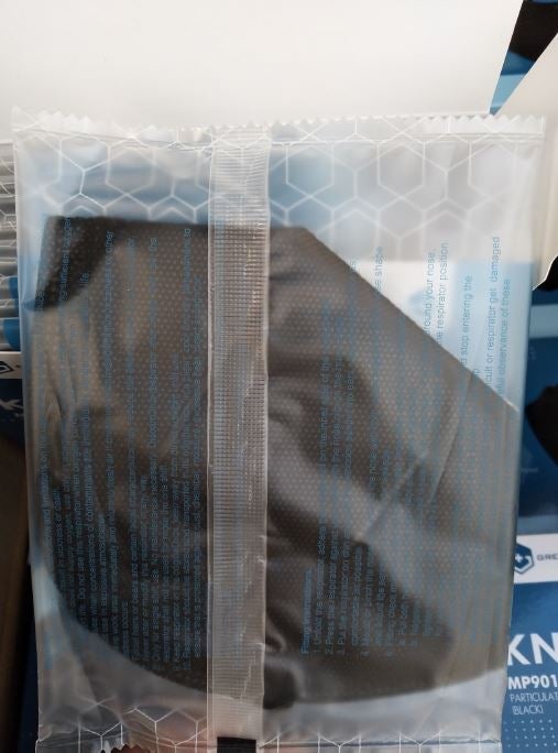 Black KN95 face mask in clear plastic wrapper