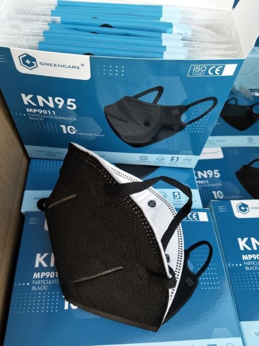 Black KN95 face mask on top of Greencare boxes