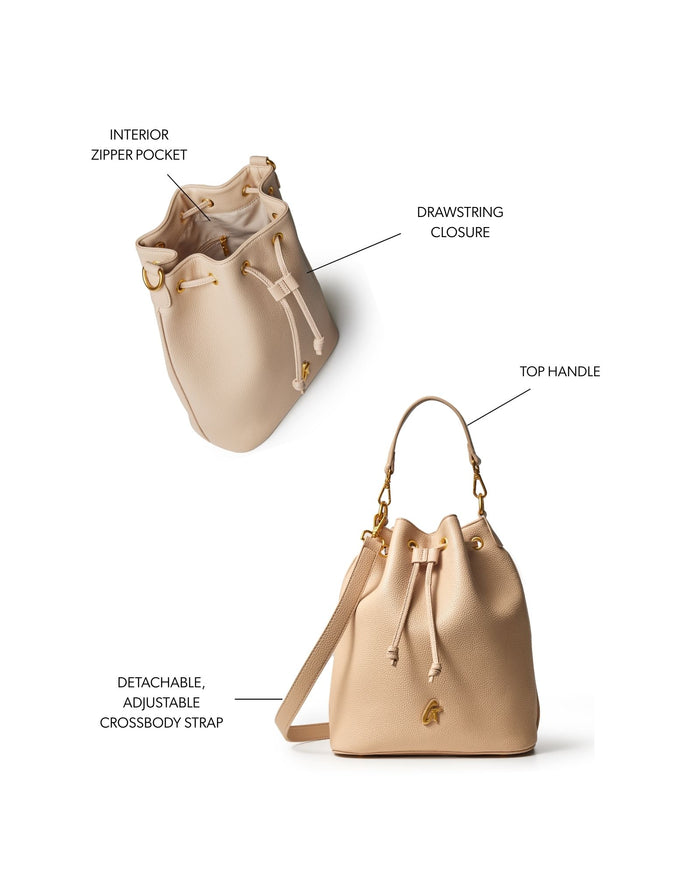 Large nude pebble bucket bag featuring a drawstring closure, top handle, and detachable adjustable crossbody strap.