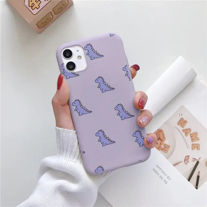 a woman holding a purple phone case with a pattern on it