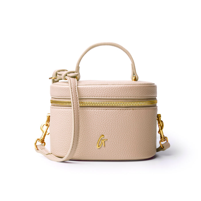 Mini pebble vanity bag in nude with gold zipper and detachable strap, perfect for stylish organization on the go.