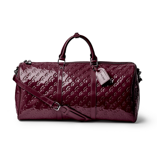 Glossy burgundy monogram duffle bag with dual handles and detachable strap, perfect for stylish travel.