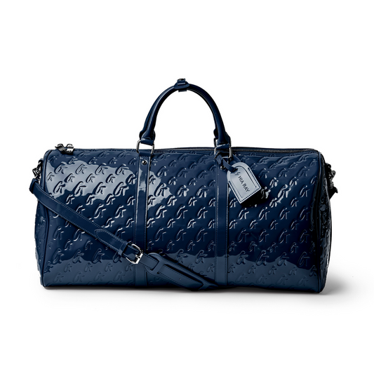 Navy monogram duffle bag with a glossy finish, featuring dual handles and a detachable shoulder strap.