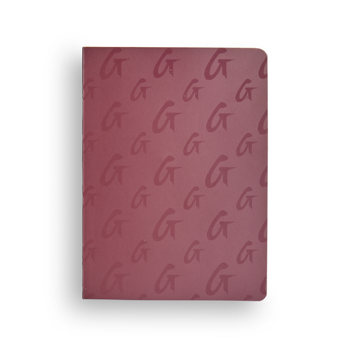Burgundy monogram notebook featuring a repeating logo pattern, perfect for stylish note-taking.