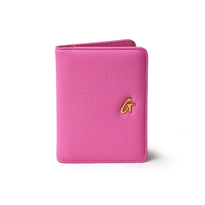 Pink Pebble Passport Holder with a gold logo, compact design, and textured faux leather surface.